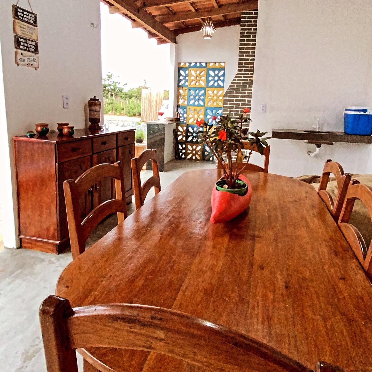 Mesa de jantar com azulejos decorativos azuis e amarelos ao fundo